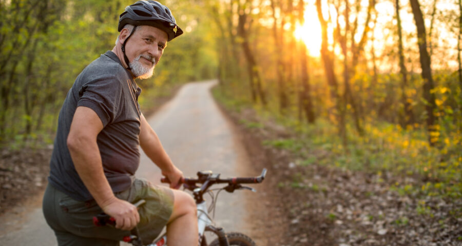An elderly man having a casual bike ride in the woods